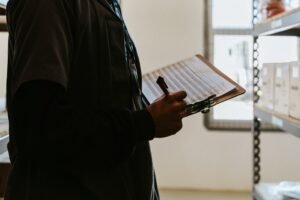 Petugas inspeksi memegang papan jalan berisi template checklist inspeksi K3