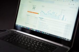 Laptop menampilkan dashboard analitik yang merepresentasikan update produk PEER