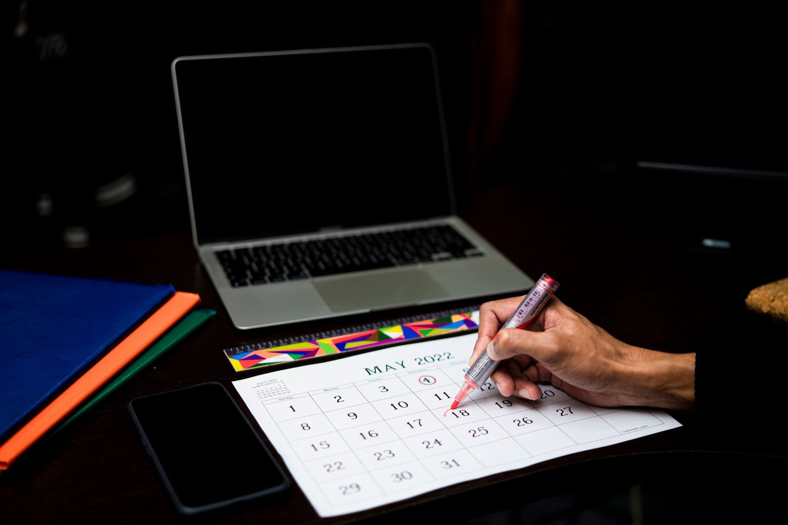 bizSAFE portal downtime: person planning application deadlines on a calendar beside a laptop