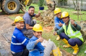 Heat stress training: group of construction workers in safety gear taking a break outside