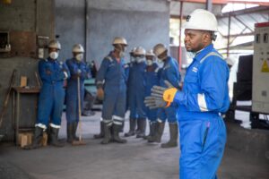 Safety induction training: factory workers in safety gear receiving a training session indoors
