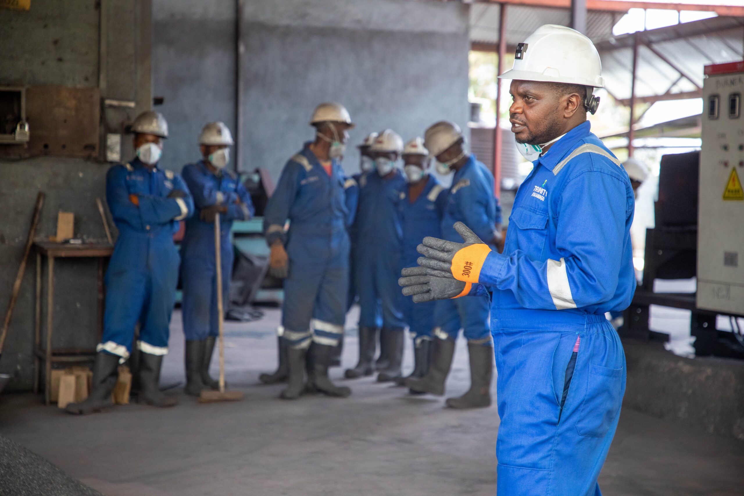 Safety induction training: factory workers in safety gear receiving a training session indoors