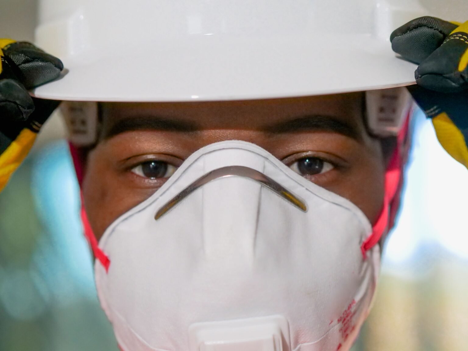 Respirator Fit Testing Training – PEER Respirator fit testing: worker wearing a hard hat and N95 respirator with a snug fit