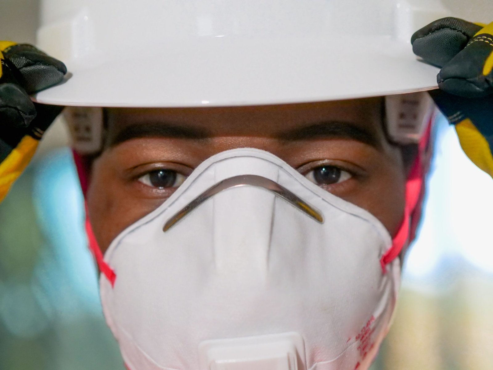 Respirator fit testing: worker wearing a hard hat and N95 respirator with a snug fit